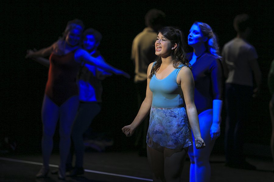 Multiple students singing in a musical theatre production