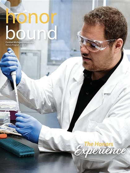 2019 cover for Honor Bound showing a student working with a pipette in a lab.