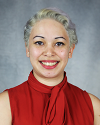 A professional headshot of Elizabeth Mcintyre in red attire against a gray background.