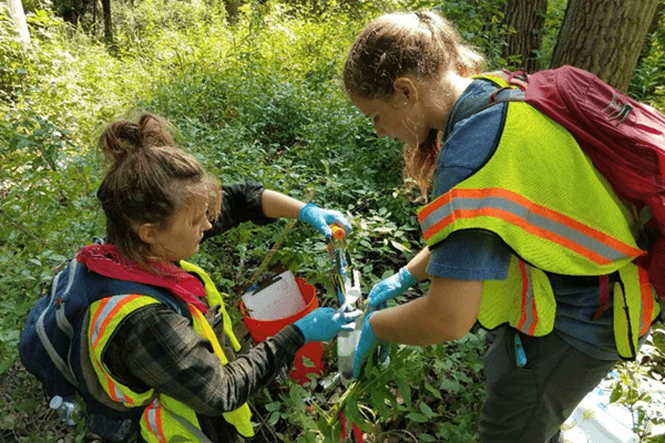 Two students conducting environmental sampling.
