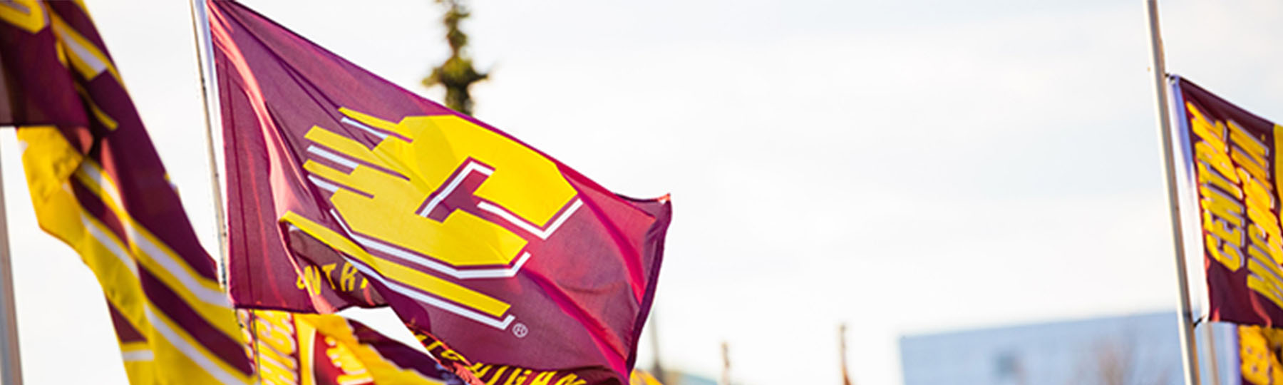 A Central Michigan University flag with a gold action C on a maroon background.