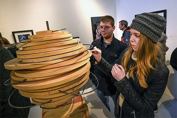 People touching an art exhibition at the University Art Gallery