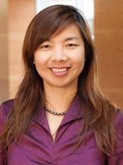 Shar Tang wears a purple blouse while smiling at the camera.