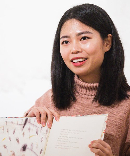 Person reading a book in their native language at the Celebration of International Children's Books.