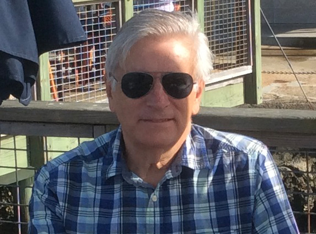 Casual headshot of historian Jack Dempsey outdoors wearing a plaid shirt and sunglasses.