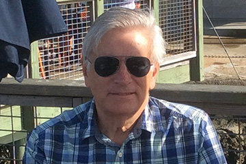 Casual headshot of historian Jack Dempsey outdoors wearing a plaid shirt and sunglasses.