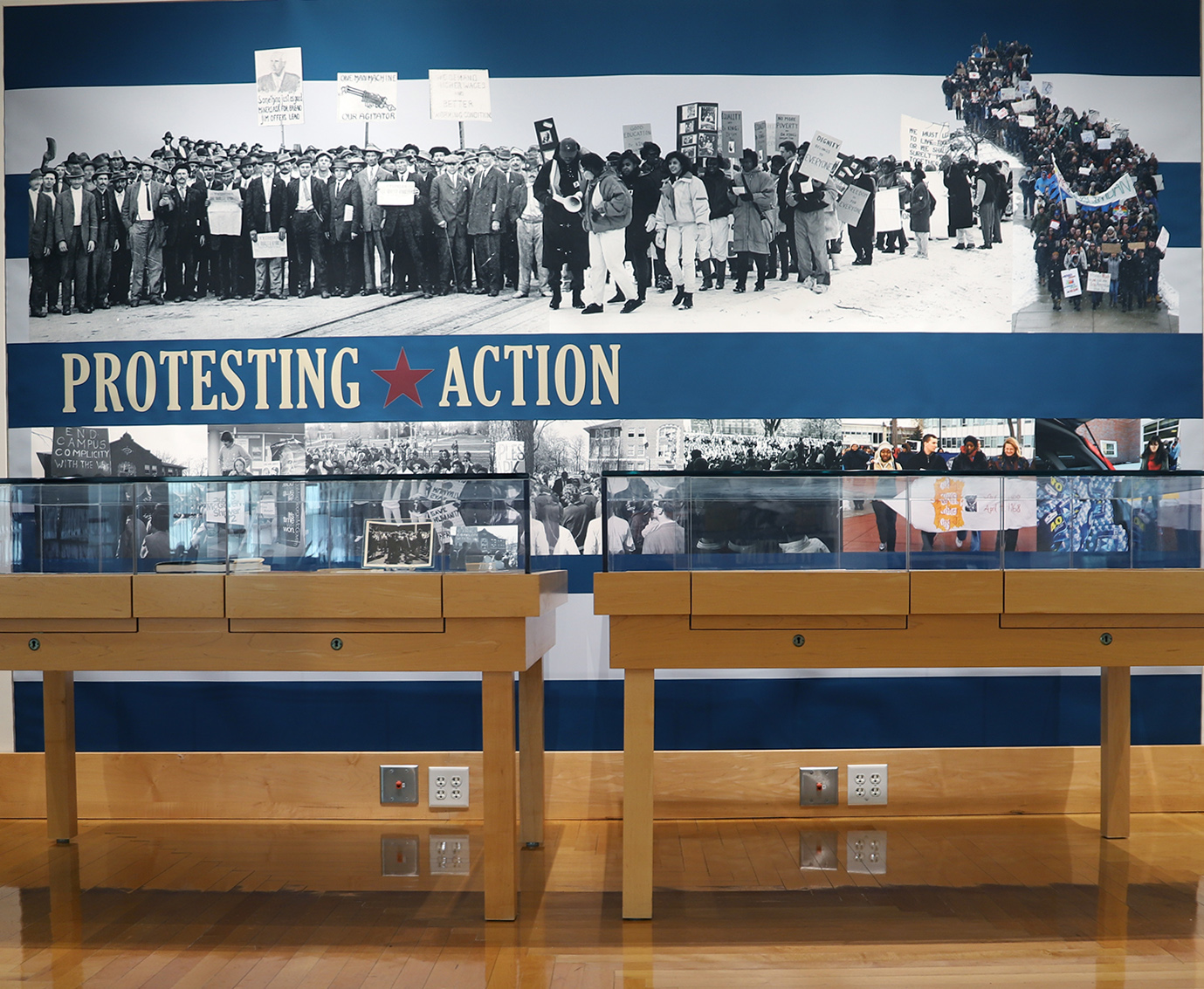 Photo of a wall graphic from the exhibit showing images of people protesting throughout history.