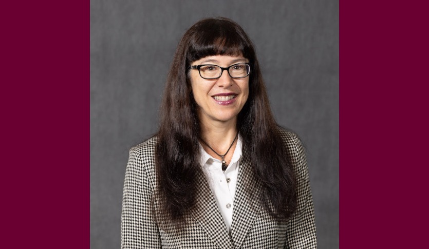 a smiling woman with long hair wearing glasses