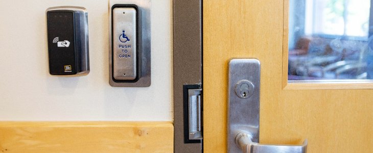 A closeup image of door handle and button for accessible entry