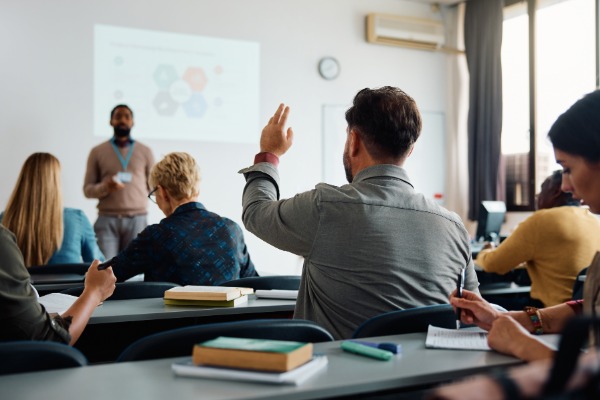 student raising their hand in class.