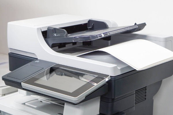 photo of a large printer with paper on the top