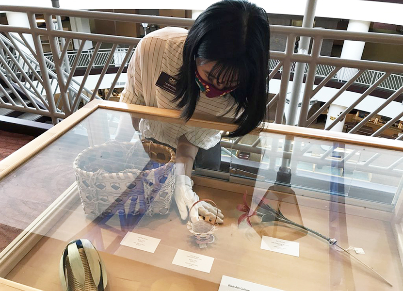 Employee placing items on display in an exhibit case