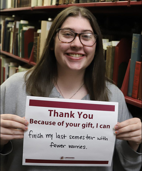 CMU Libraries Scholarship Recipient holding a that says 