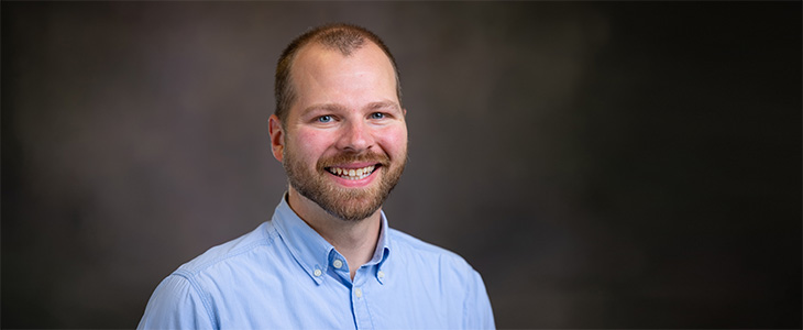 Bryan Whitledge wears a blue button up and smiles for the camera.