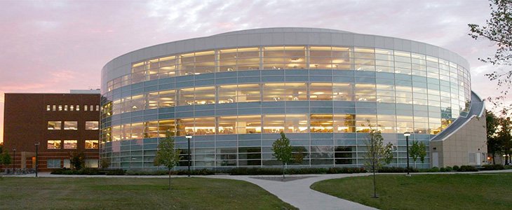 Outside image of CMU Park Library during the early evening with view of interior building lights