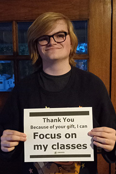 Library Scholarship Recipient David Neese holding a sign that reads 