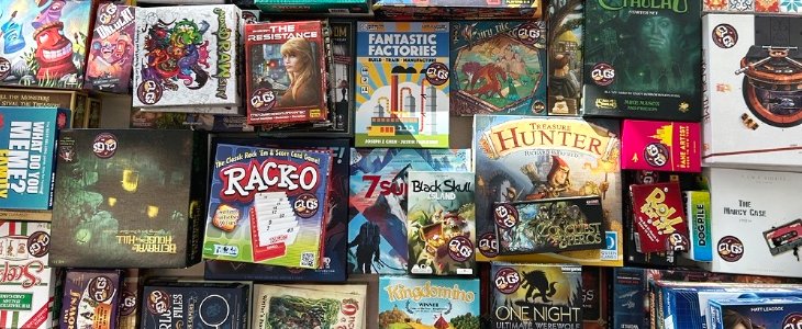 Overview image looking down at a table covered in Board Games that have recently been added to the Library's collection from CMU's CLGS organization. A few games to note are Rack-o, Black Skull Island, Treasure Hunter, Azul and many many more.