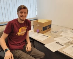 Clarke Historical Library Student Employee Matt wearing a maroon shirt working on archives