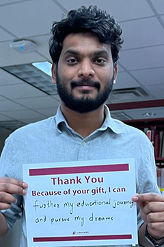 Library Scholarship Recipient Saiteja Puli holding a sign that reads 