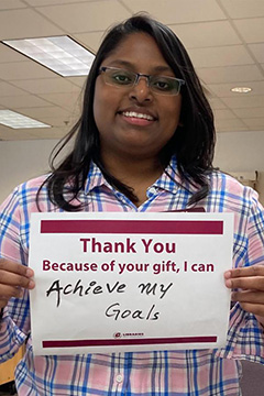Library Scholarship Recipient Sherly Tandra holding a sign that reads 