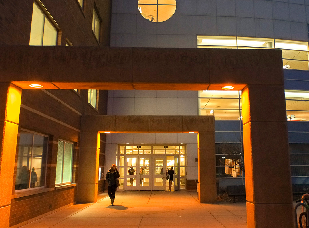 Students walking in and out of Park Library at night.