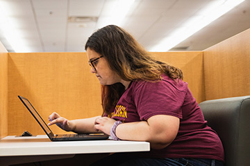 Student working on a laptop in the Library