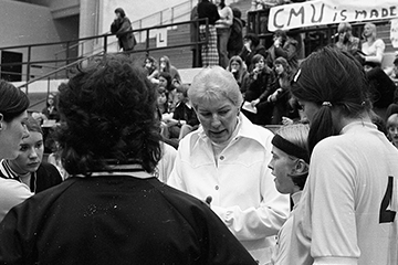 Coach Fran Koenig talks to her basketball team, 1970s