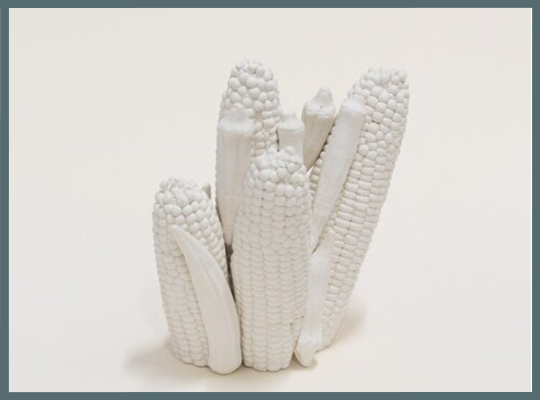 white sculpture of grouping of corn cobs on a white background