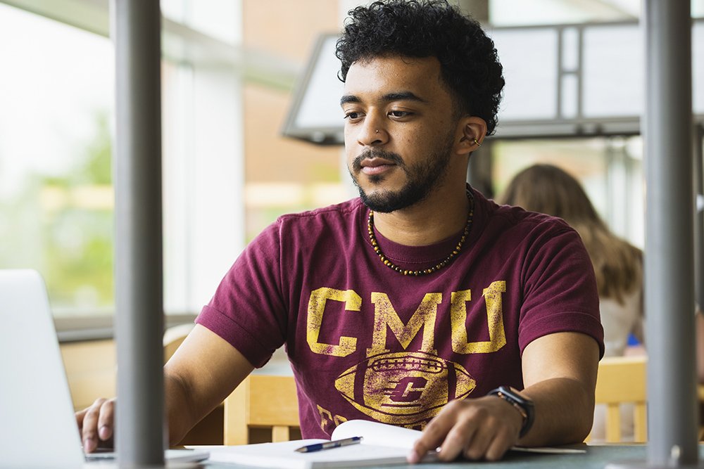 A student studying and working on a laptop.