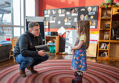 A Central Michigan University student talks with a young girl.
