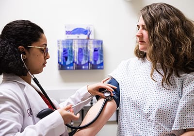 A College of Medicine student participates in a lab simulation with a patient.