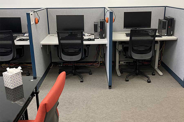 Two empty computer testing station desks