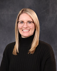 Audrey Show portrait, showing head and shoulders, smiling, on a gray background