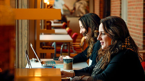 Two women studying at their computers