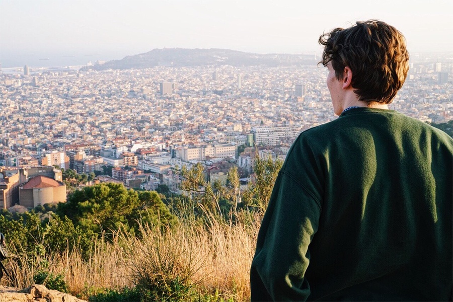 A Central Michigan University student stands on a hill overlooking Barcelona.