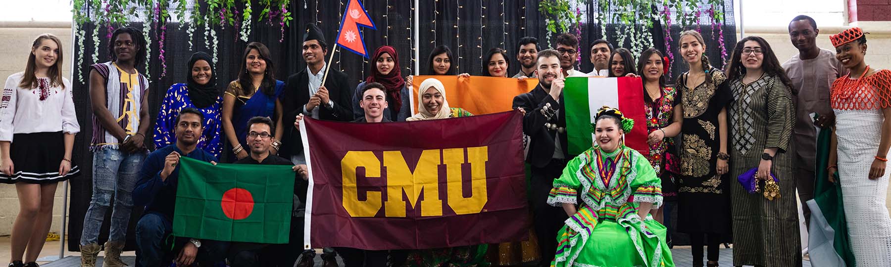 International students holding a CMU flag at the International Student Expo.