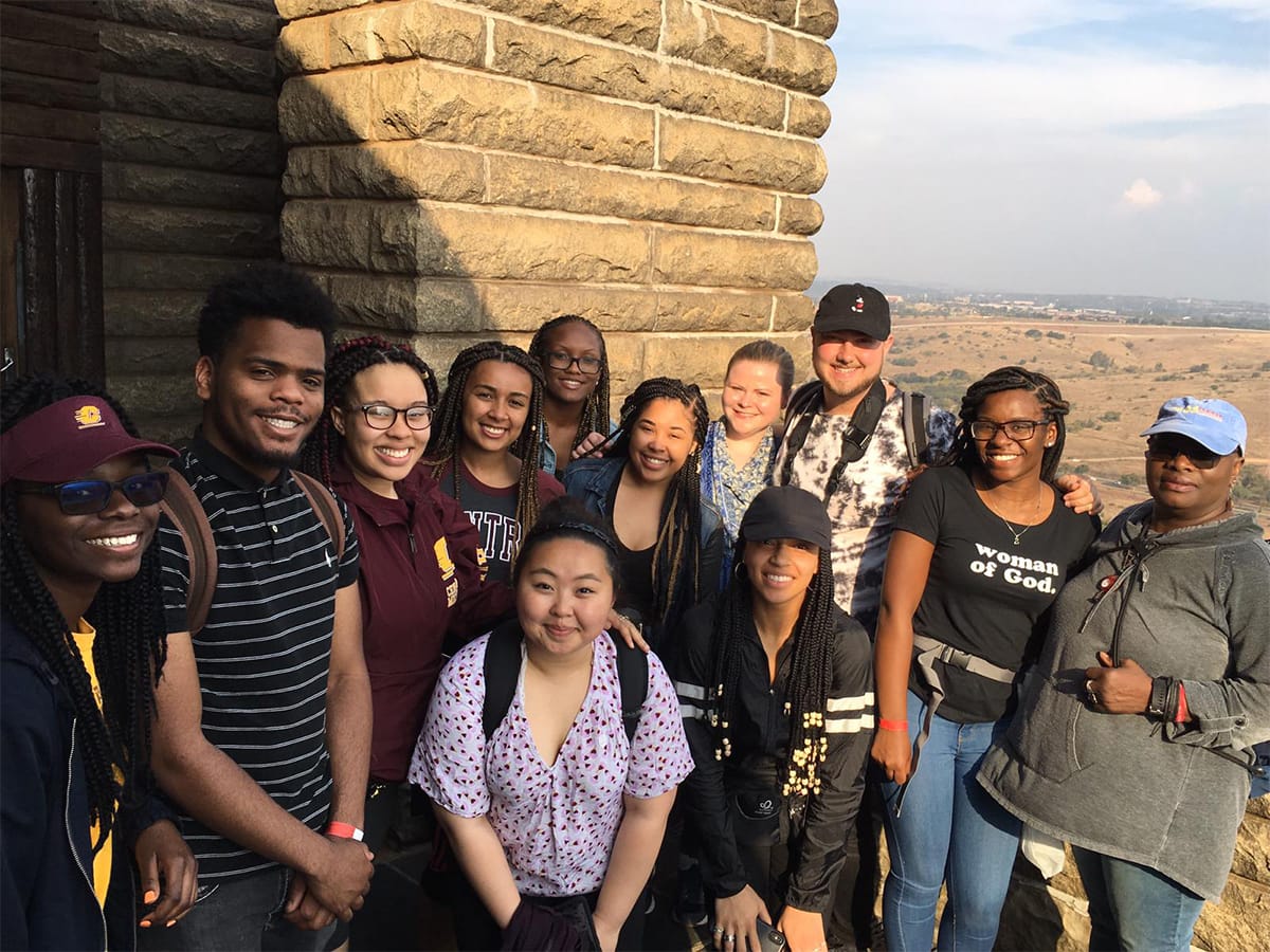 A diverse group of students studying abroad pose for a picture in South Africa.