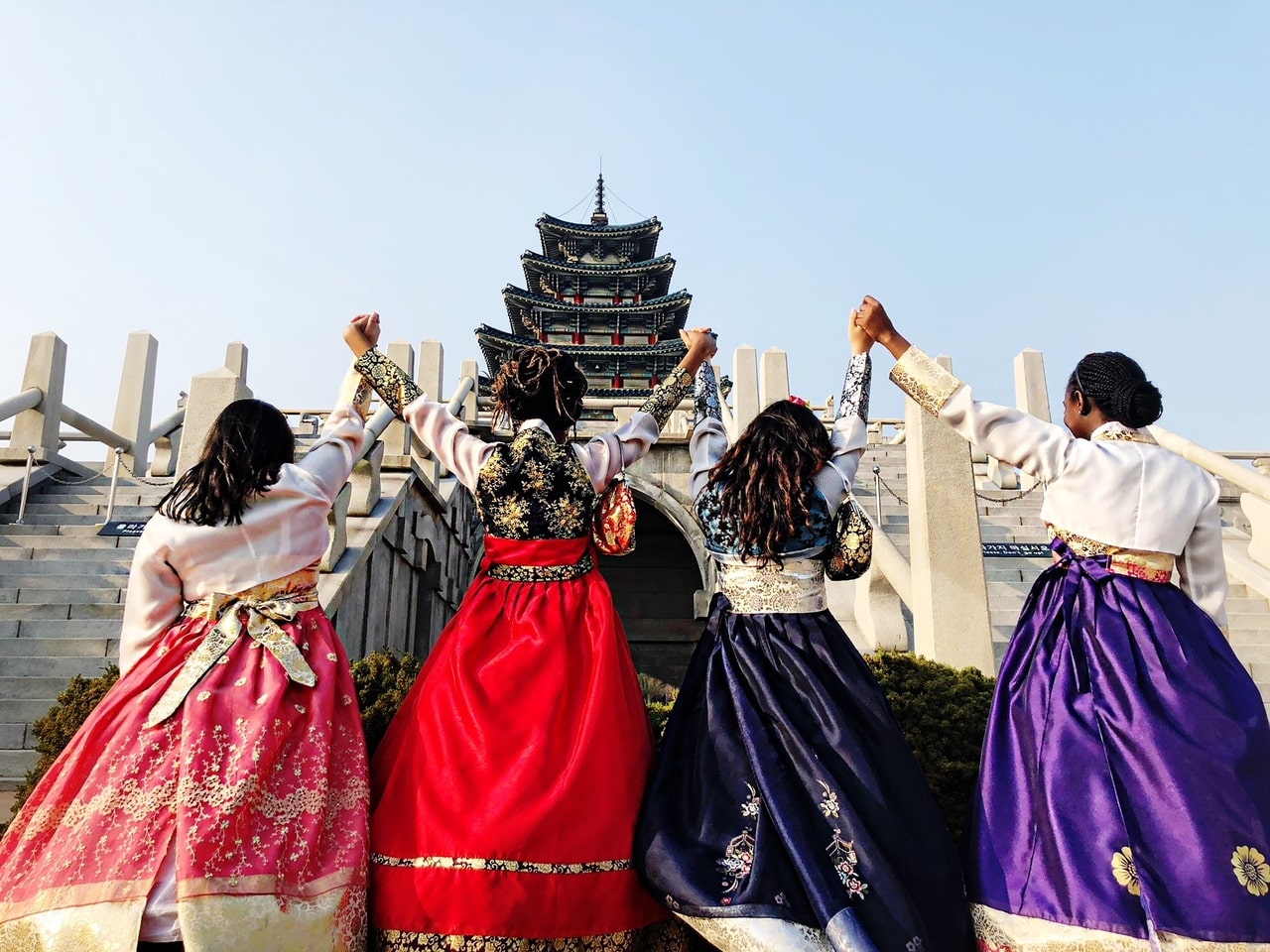 Students holding hands in traditional attire in South Korea.