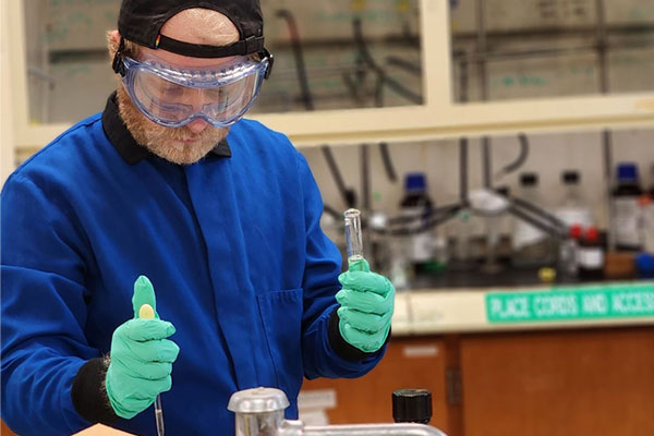 Chemistry student, Jacob Lentz, working in a lab.