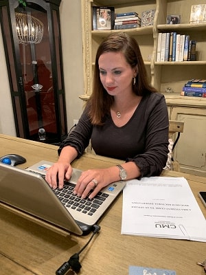 Misty Hauser sitting at a table while working on a computer.