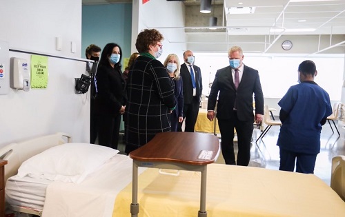 Individuals viewing a nursing simulation room