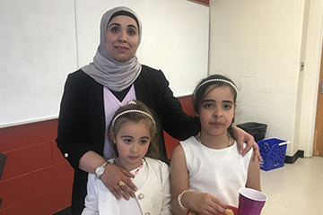 Recent graduate, Rasha Almughrabi, posing for a picture with her two daughters.