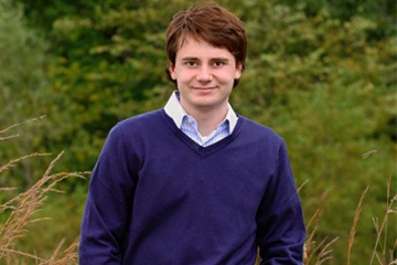A man wearing a blue sweater posing for a picture.