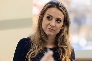 A woman in a dark blue shirt looking to the side.