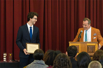 A man holding a certificate.