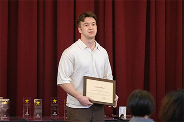 A man holding a certificate.