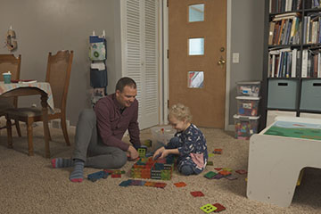 A man and child playing with toys.