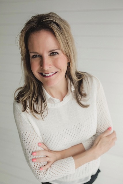 Dr. Deborah M. Gray wears a white blouse and sweater while looking at the camera.