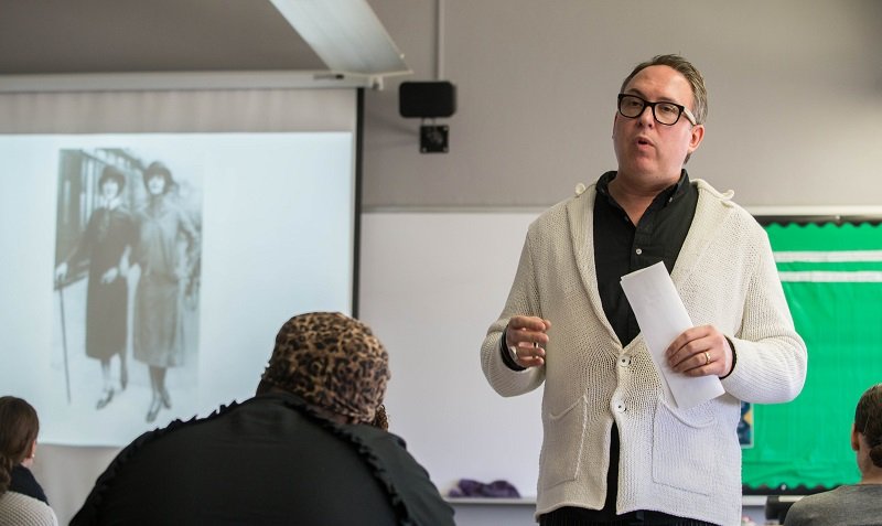 Dr. Michael Mamp standing in the front of a classroom and giving a lecture to students.