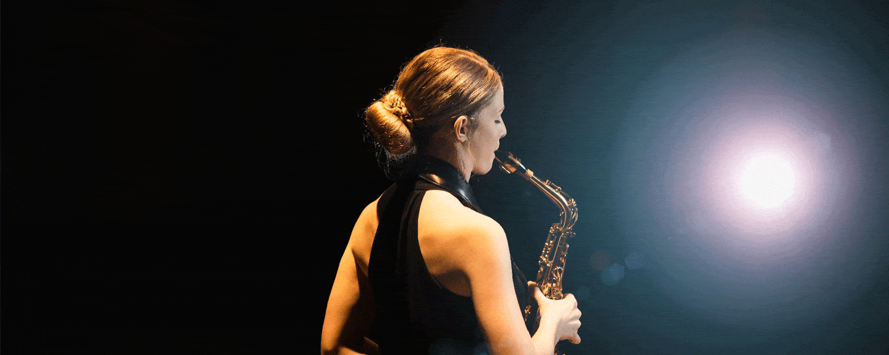 Picture of a student playing the saxophone highlighting the work of the School of Music in live-streaming concerts.